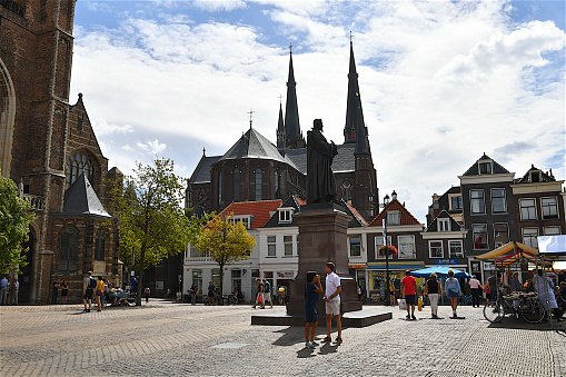 City view of the market square of Delft,The Hugo de Groot monument surrounded by old traditional dutch style houses.