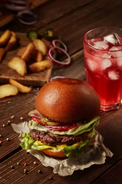 Burger with lemonade and fried potatoes.
