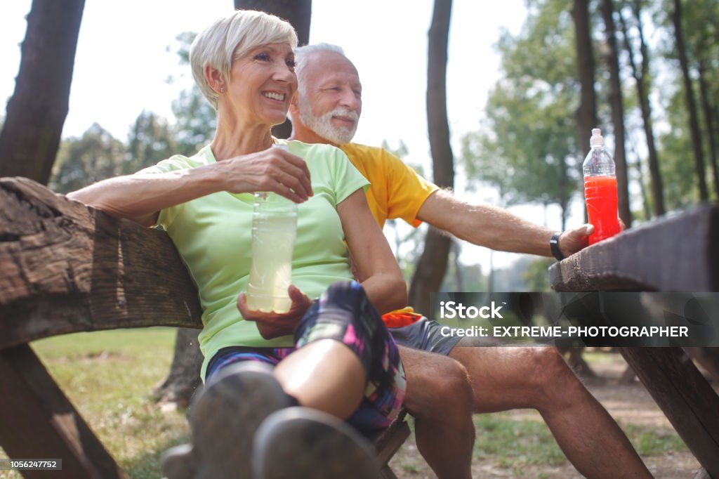 Senior couple outdoors Active senior couple resting after exercising outdoors. Energy Drink Stock Photo