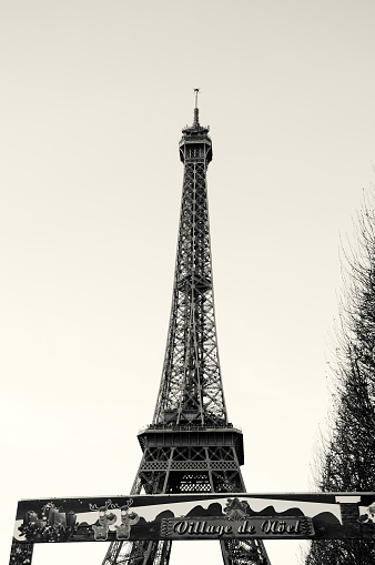 PARIS, FRANCE - DECEMBER 26, 2015: Christmas market near Eiffel tower. Entry banner. Black and white photo.