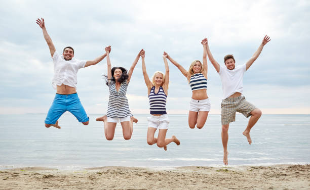 istock smiling friends in sunglasses walking on beach 1056252310