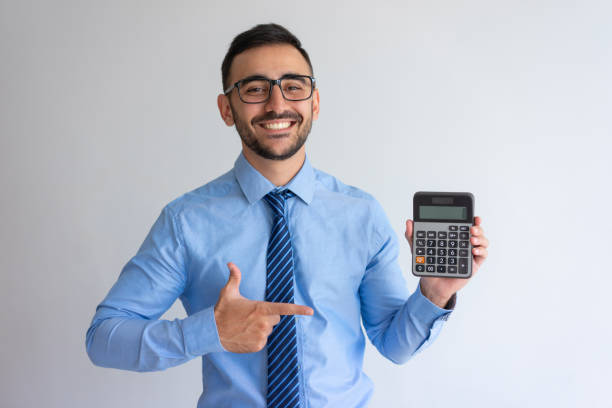 Cheerful banker advertising loan program Cheerful banker advertising loan program. Content young man in glasses and tie pointing at calculator. Finance or banking concept zero photos stock pictures, royalty-free photos & images
