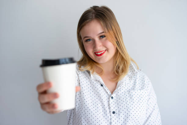 istock Cheerful girl offering coffee 1056257258
