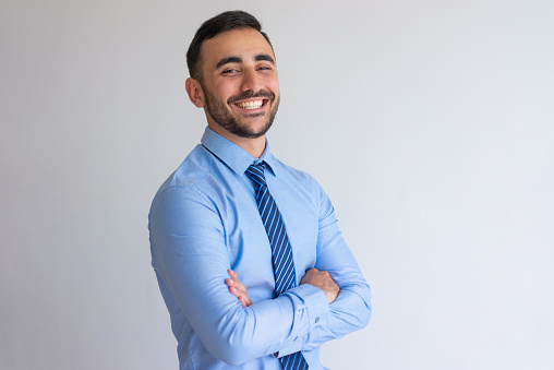 Young smiling well dressed businessman posing for a shot at the office