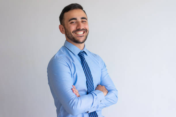 Portrait of joyful professional Portrait of joyful professional. Young business man blue shirt and tie crossing arms and smiling at camera. Successful businessman concept trader stock pictures, royalty-free photos & images