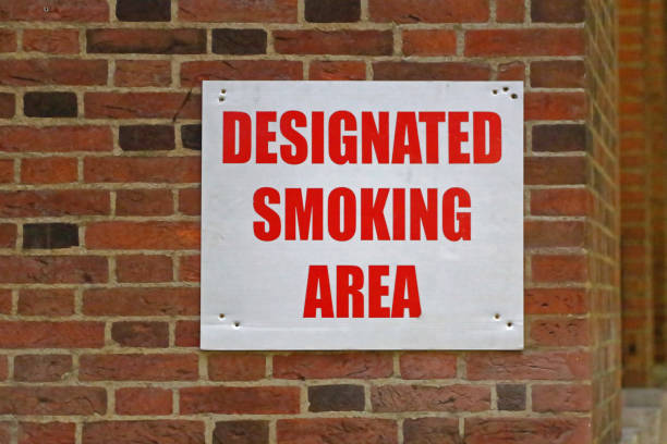 Smoking Area Designated Smoking Area Sign at Building Corner corner tip stock pictures, royalty-free photos & images