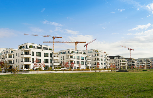 Duesseldorf, Germany- Oct., 12, 2018: New luxury townhouses in the new development area between Duesseldorf-Oberkassel and Duesseldorf-Heerdt, four cranes in the background.