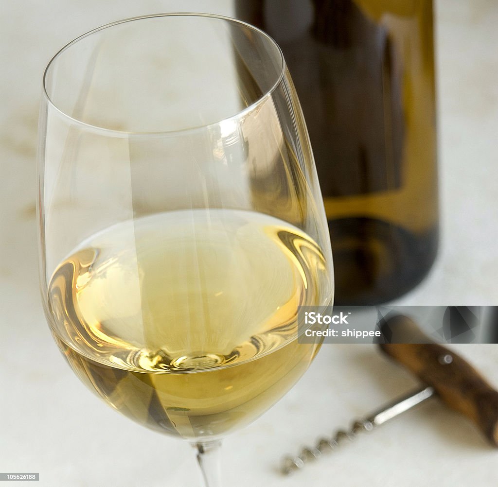 Bottle of Chardonnay wine, corkscrew and a glass glass of chardonnay, simple props, natural light Alcohol - Drink Stock Photo