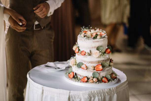 istock A bride and a groom is cutting their wedding cake 1056263392