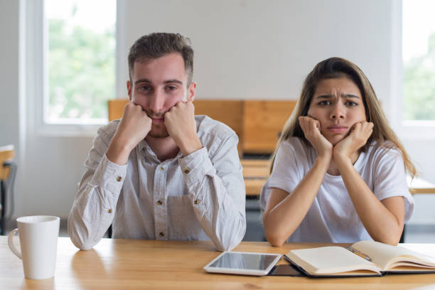 istock Bored male and female students studying in classroom 1056263442