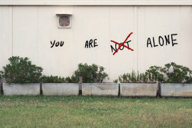 you are not alone - graffiti believe wall single word imagens e fotografias de stock