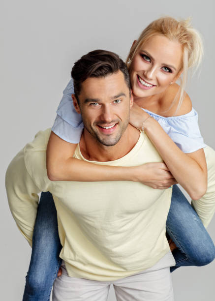 istock Young smiling man piggyback his beautiful girlfriend 1056266718