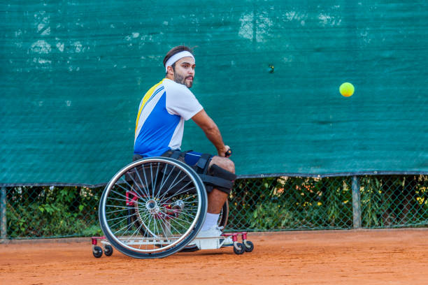 disabled tennis player hits the ball disabled tennis player hits the ball backhand during a match outdoor wheelchair tennis stock pictures, royalty-free photos & images