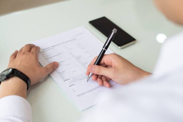 istock Hands of businessman or student filling application form 1056269946