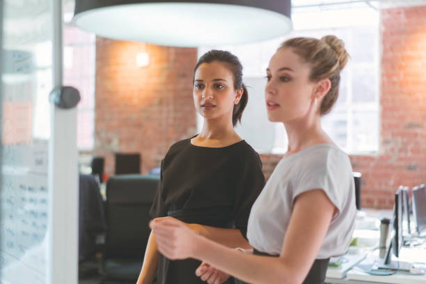 istock Young businesswomen planning over whiteboard 1056272382