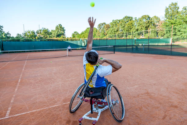 disabled tennis player hits the ball stock photo