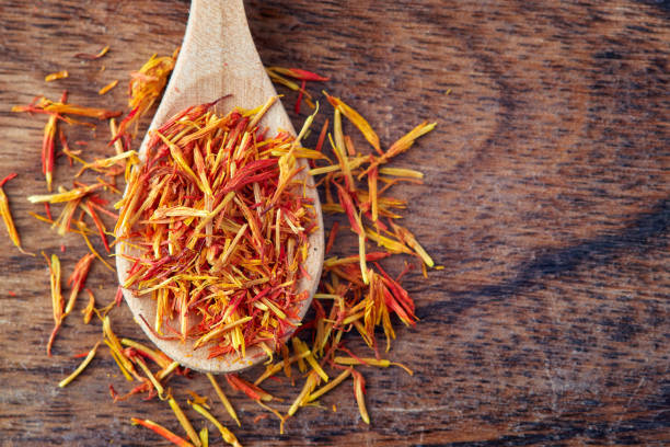Safflower petals (Saffron substitute) Safflower petals (Saffron substitute) in wooden spoon. Top view with copy space substitute for saffron stock pictures, royalty-free photos & images