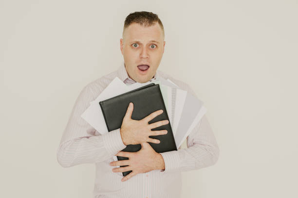 istock Frightened shocked employee buried in paperwork 1056281370