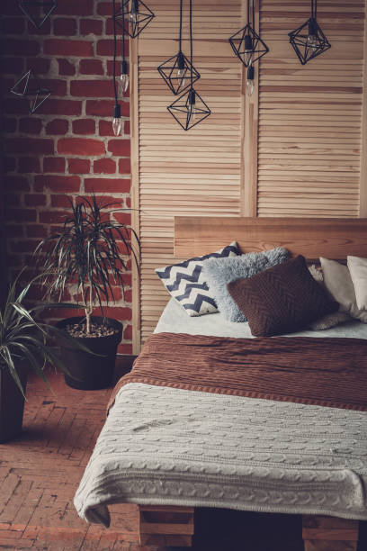 istock Simple bedroom with double bed, red brick wall and big window 1056284724