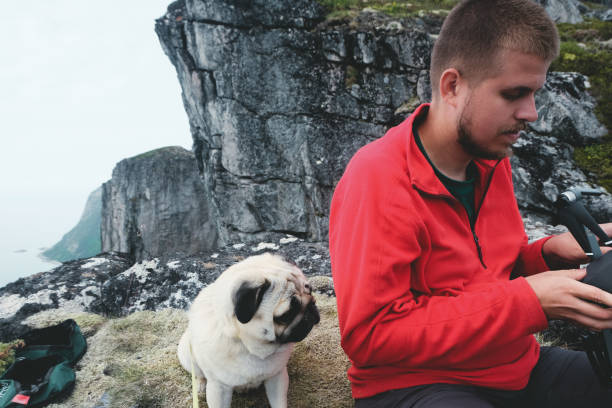 istock Man and dog flying drone at Norway mountains 1056284944