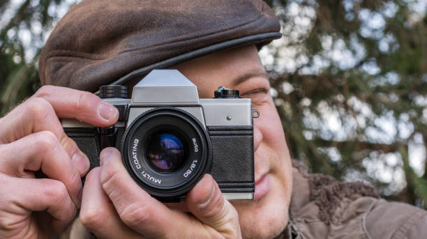 istock Man is photographing in nature with old analog camera 1056289232