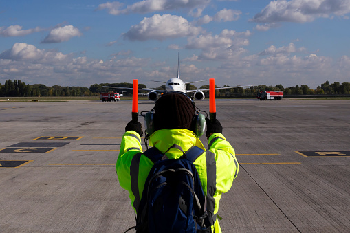 A supervisor helps at the aircraft parking at the airport
