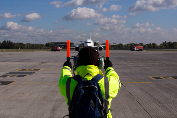 A supervisor helps at the aircraft parking A supervisor helps at the aircraft parking at the airport airplane landing stock pictures, royalty-free photos & images