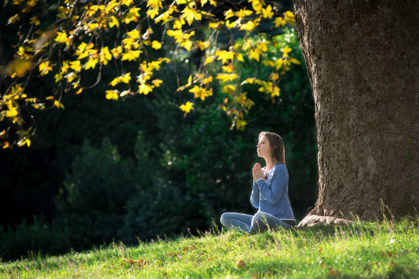 istock Girl meditates sitting on the grass under a maple tree in autumn 1056292394