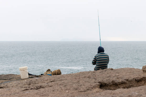 istock Man fishing in the cliff 1056296580
