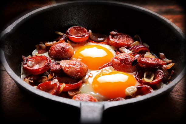 istock Cooked egg and sausages on rying pan, tasty english breakfast 1056297278