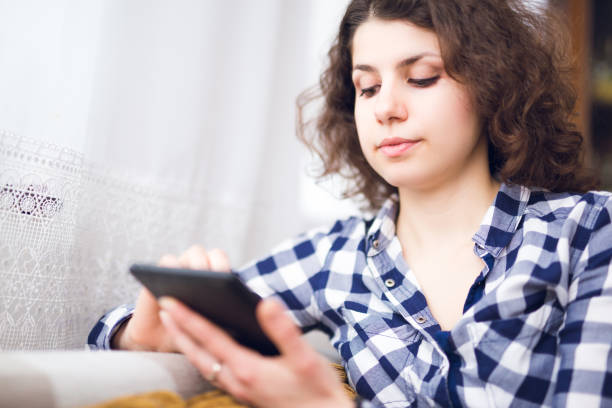 istock Young woman relaxing indoor and using tablet. 1056301650