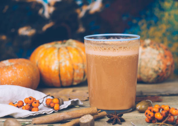 vegan pumpkin pie smoothie with spices. healthy fall smoothie recipe: dairy-free smoothie with almond milk, pumpkin puree and banana. background with pumpkins, an old wooden table. - fruit freshness tree foods and drinks imagens e fotografias de stock