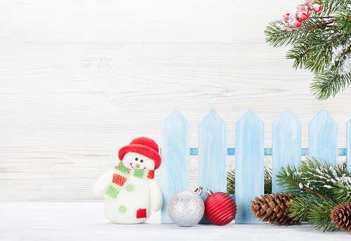 Christmas snowman toy, decor and fir tree branch. Xmas greeting card with space for your greetings