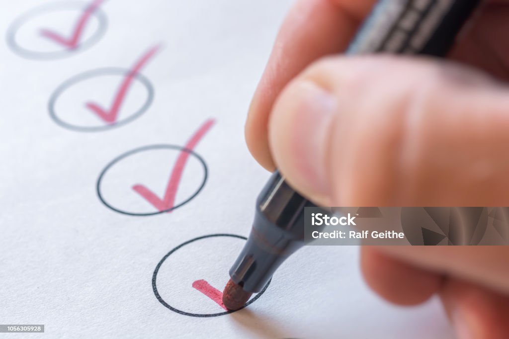 Checking completed tasks on a list controling Checklist Stock Photo