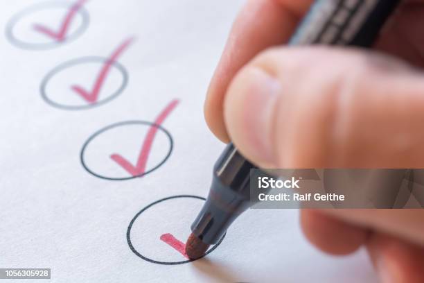 Checking Completed Tasks On A List Stock Photo - Download Image Now - Checklist, List, Examining