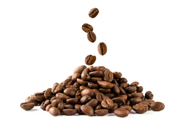 Photo of A bunch of coffee beans and falling coffee beans on a white background. Isolated.