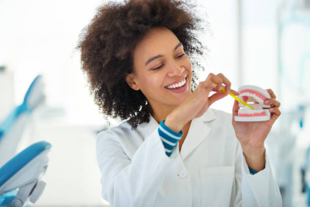 dentist showing the proper way of brushing teeth. - brushing teeth women toothbrush brushing imagens e fotografias de stock