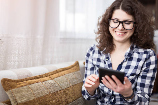 istock Woman sitting on bed  and using her tablet. 1056308378