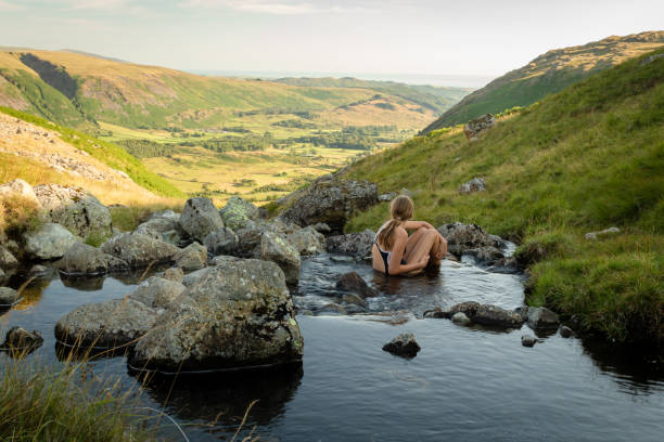 une jeune fille se baignant dans le flux de greendale gill et belle vue sur la vallée de wasdale dans le lake district national park (uk) en regardant sur une soirée ensoleillée. - wastwater lake photos et images de collection