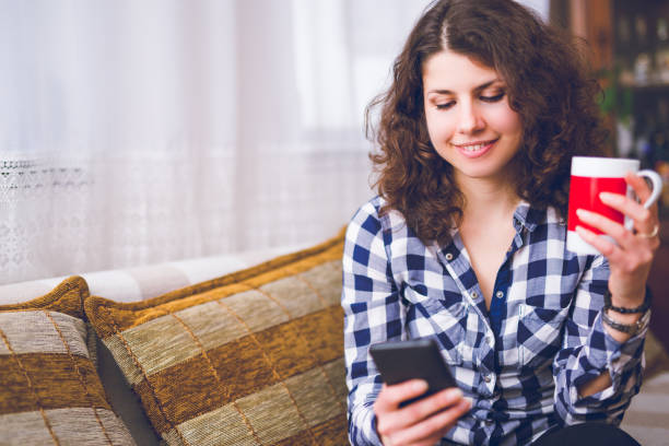 istock Woman relaxing with cup of coffee and using mobile phone. 1056309380