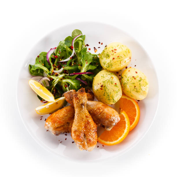 istock Roast chicken drumsticks with boiled potatoes and vegetable salad 1056313378
