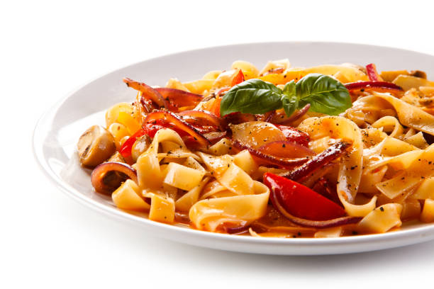 istock Pasta, pesto sauce and vegetables on white background 1056313844