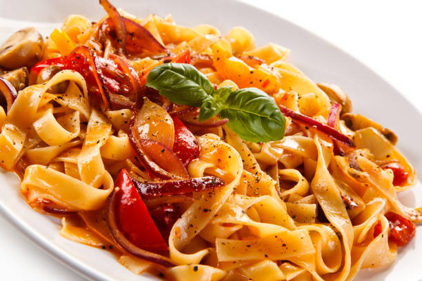 istock Pasta, pesto sauce and vegetables on white background 1056313916