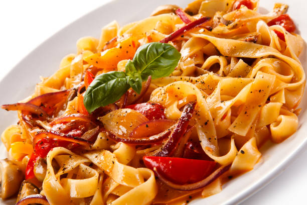 istock Pasta, pesto sauce and vegetables on white background 1056313946