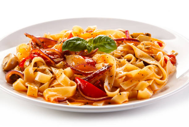 istock Pasta, pesto sauce and vegetables on white background 1056314012