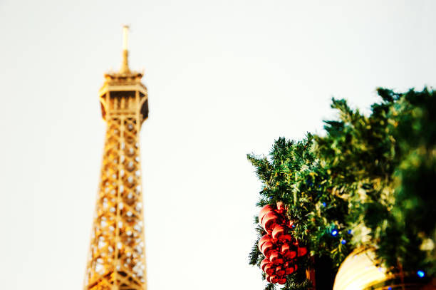 Eiffel tower and Christmas decoration. Toned photo. Selective focus on red balls.