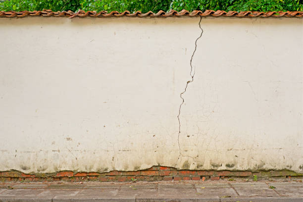 istock Abandoned cracked dirty stucco white wall background. 1056315674
