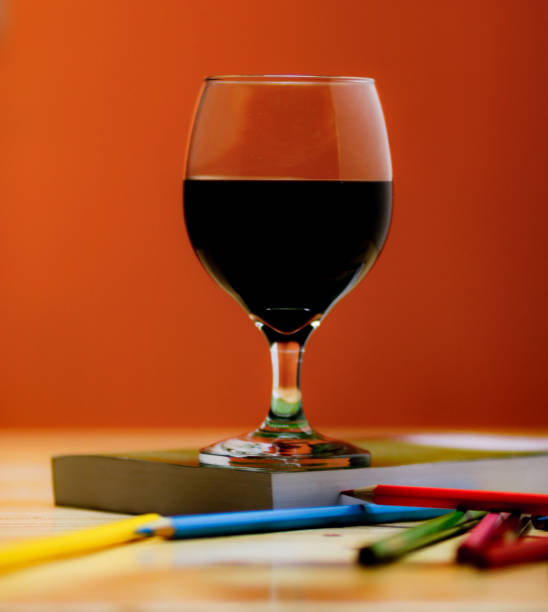 istock Glass of wine on a book. 1056320280