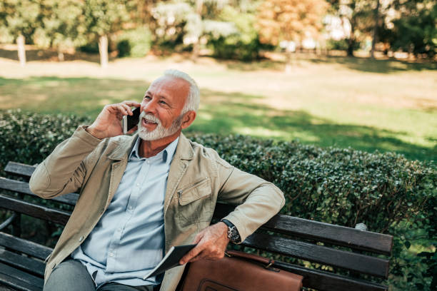 istock Older man talking on the mobile phone while sitting in the park. 1056321850