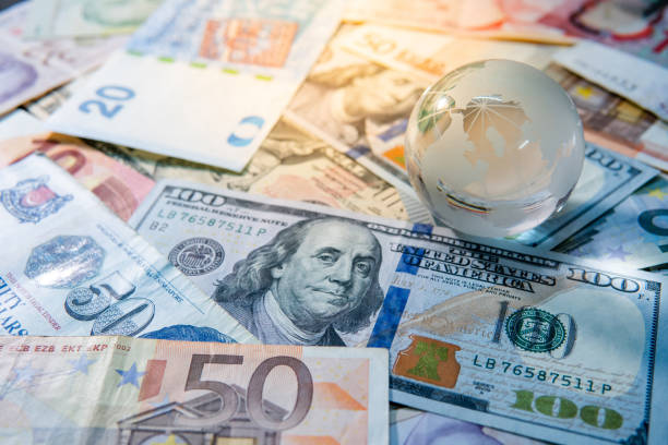 Global business and economy. World globe crystal glass on various international money banknotes. Currency exchange rate. Financial investment concept stock photo